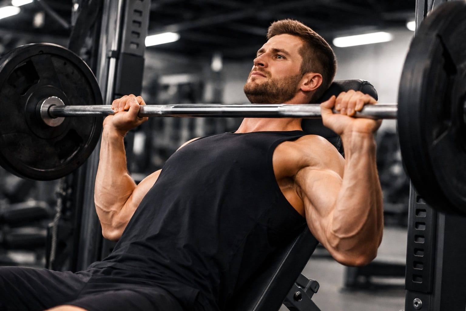 Smartphone displaying workout log app next to gym equipment showing progress tracking